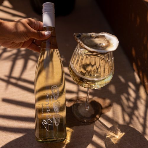 Brine wine bottle with glass of wine beside